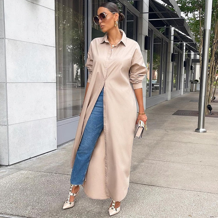 Frau in beigem Hemdkleid, Jeans, Sonnenbrille, High Heels, städtische Umgebung.