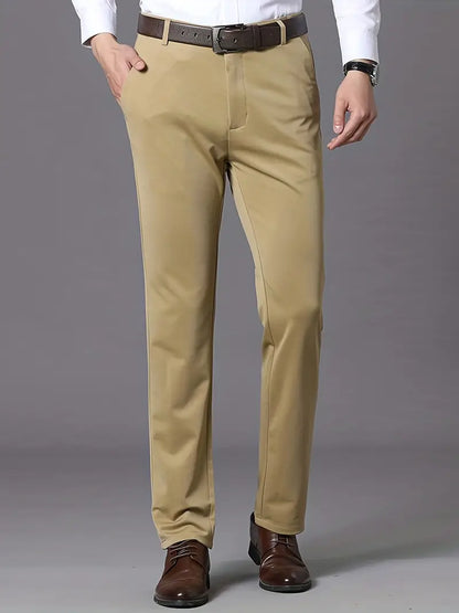 Beige Herren-Chinohose, gerade geschnitten, aus Baumwolle, mit braunem Ledergürtel und braunen Schuhen.