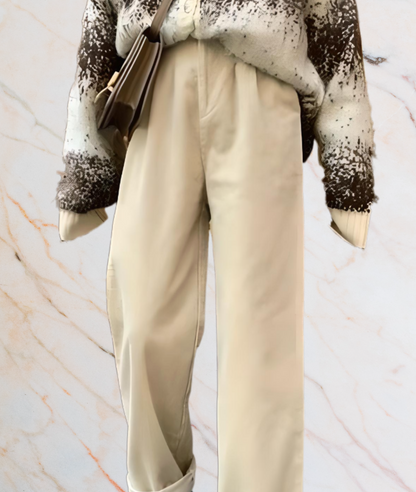 Beige Hose, brauner Pullover, Umhängetasche, Marmorhintergrund, modisches Outfit.