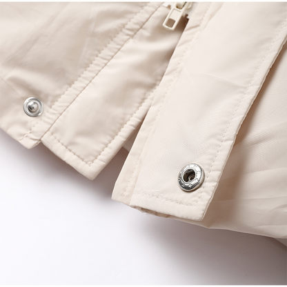 Beige Daunenjacke Detailansicht, Reißverschluss, Druckknöpfe, Wintermode, hochwertige Materialien.
