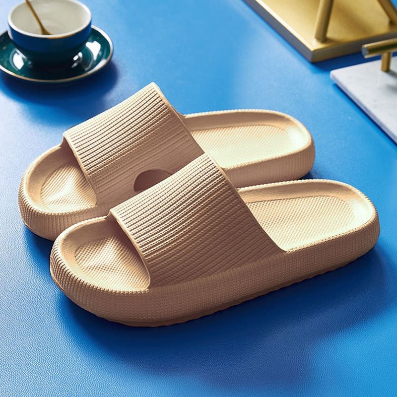 Beige Pantoletten aus Kunststoff auf blauem Hintergrund, ideal für Komfort und Freizeit.