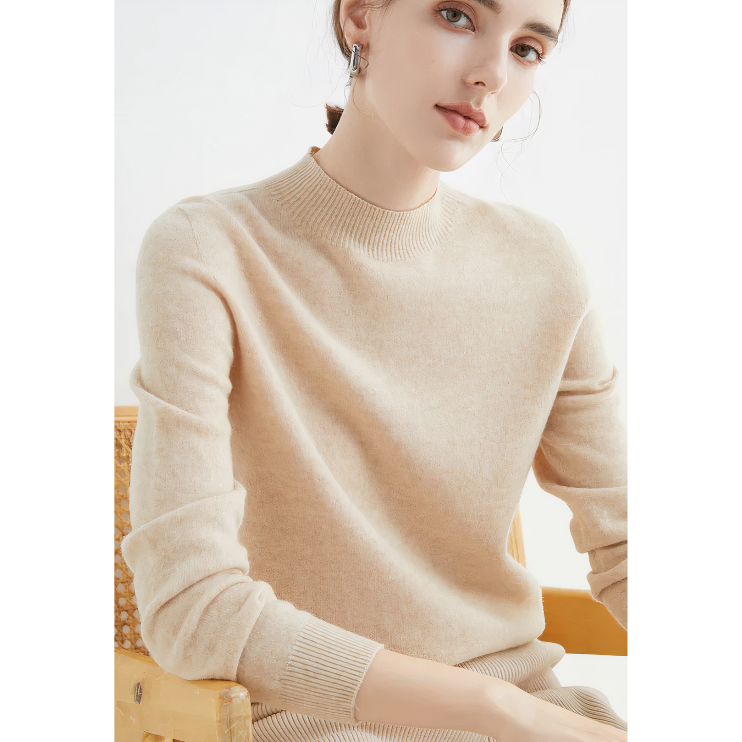 Frau in beigem Kaschmirpullover, sitzt auf Stuhl, elegantes Design, Herbstmode.