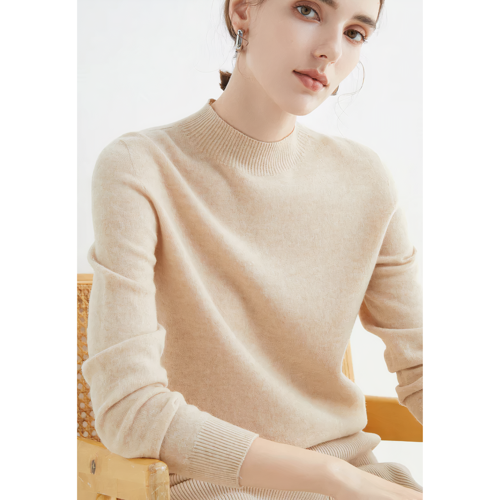 Frau in beigem Kaschmirpullover, sitzt auf Stuhl, elegantes Design, Herbstmode.