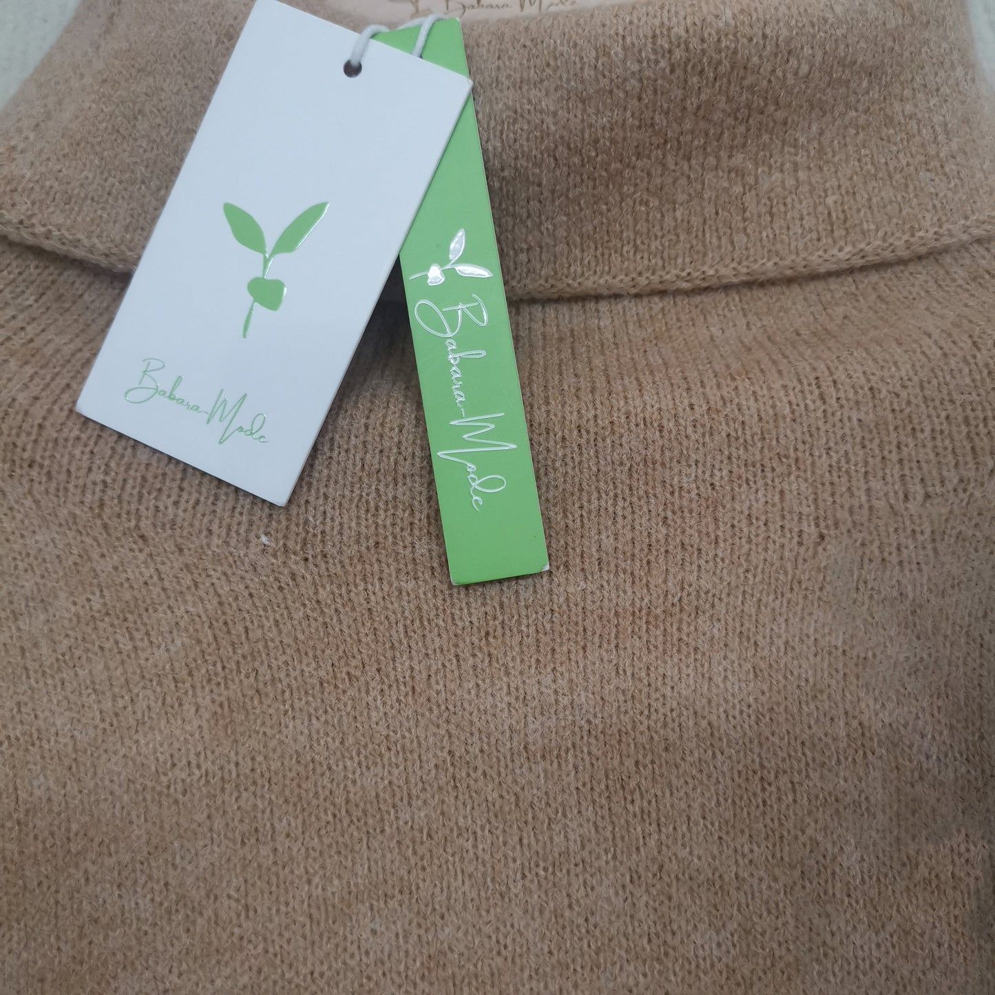Beigefarbener Rollkragenpullover aus Wolle mit Etiketten, nachhaltige Mode, Damenbekleidung.