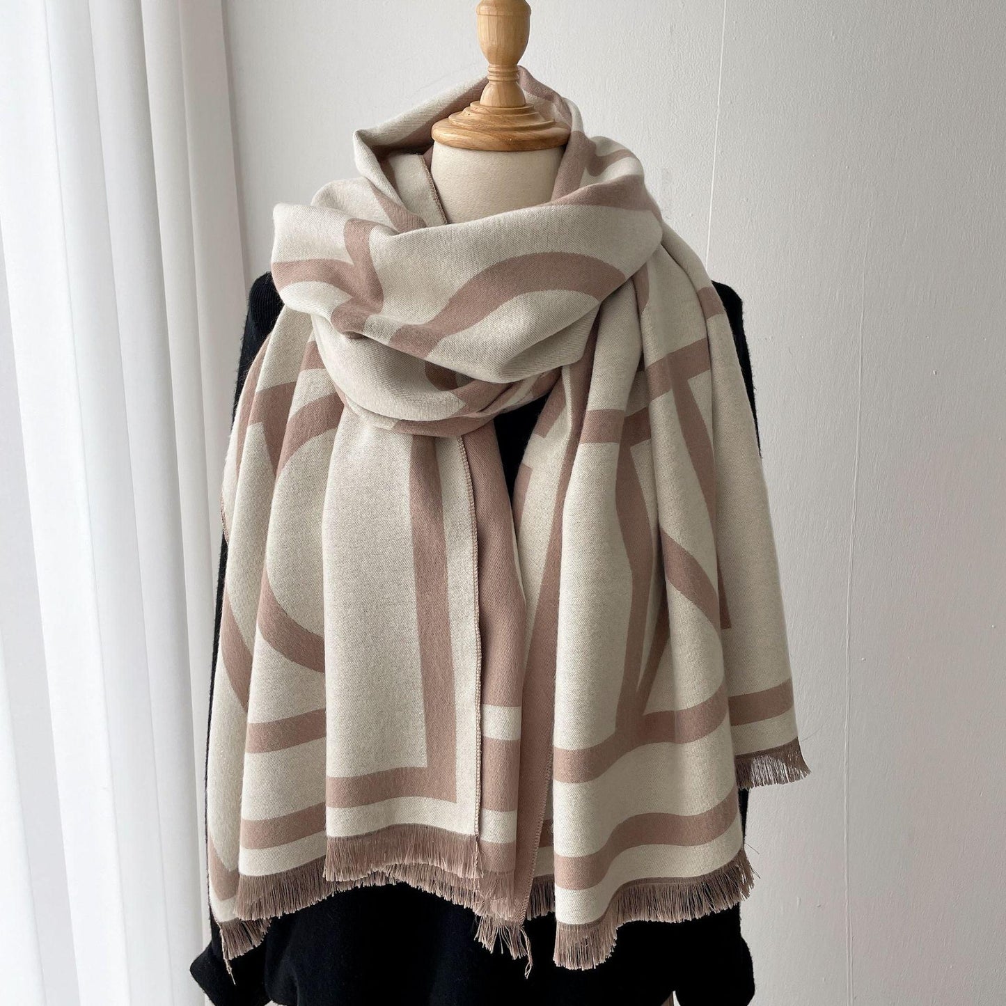 Beige-weißer Schal mit geometrischem Muster, weicher Stoff, Damenmode, Herbst-Winter-Accessoire.