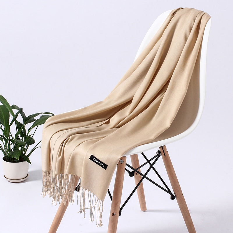 Beiger Kaschmirschal auf weißem Stuhl, weiches Material, Fransen, elegantes Design, Wohnzimmer.