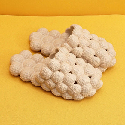 Beige Massageslipper aus Gummi auf gelbem Hintergrund, ergonomisch, rutschfest, bequem.