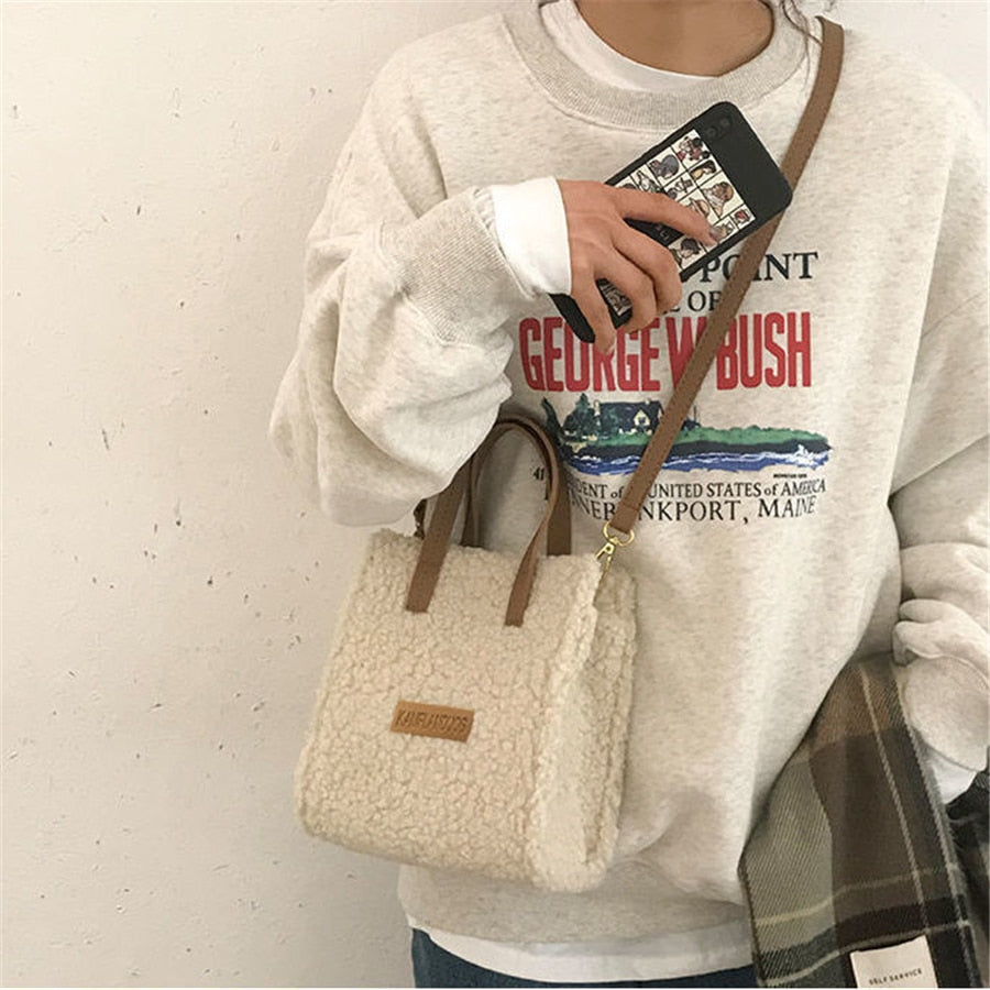 Damenhandtasche aus beigem Teddyfell, braune Griffe, lässiger Stil, modisches Accessoire.