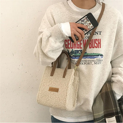 Damenhandtasche aus beigem Teddyfell, braune Griffe, lässiger Stil, modisches Accessoire.