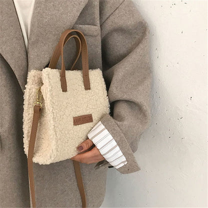 Damenhandtasche aus beigem Teddyfell mit braunen Ledergriffen, modisch und elegant.