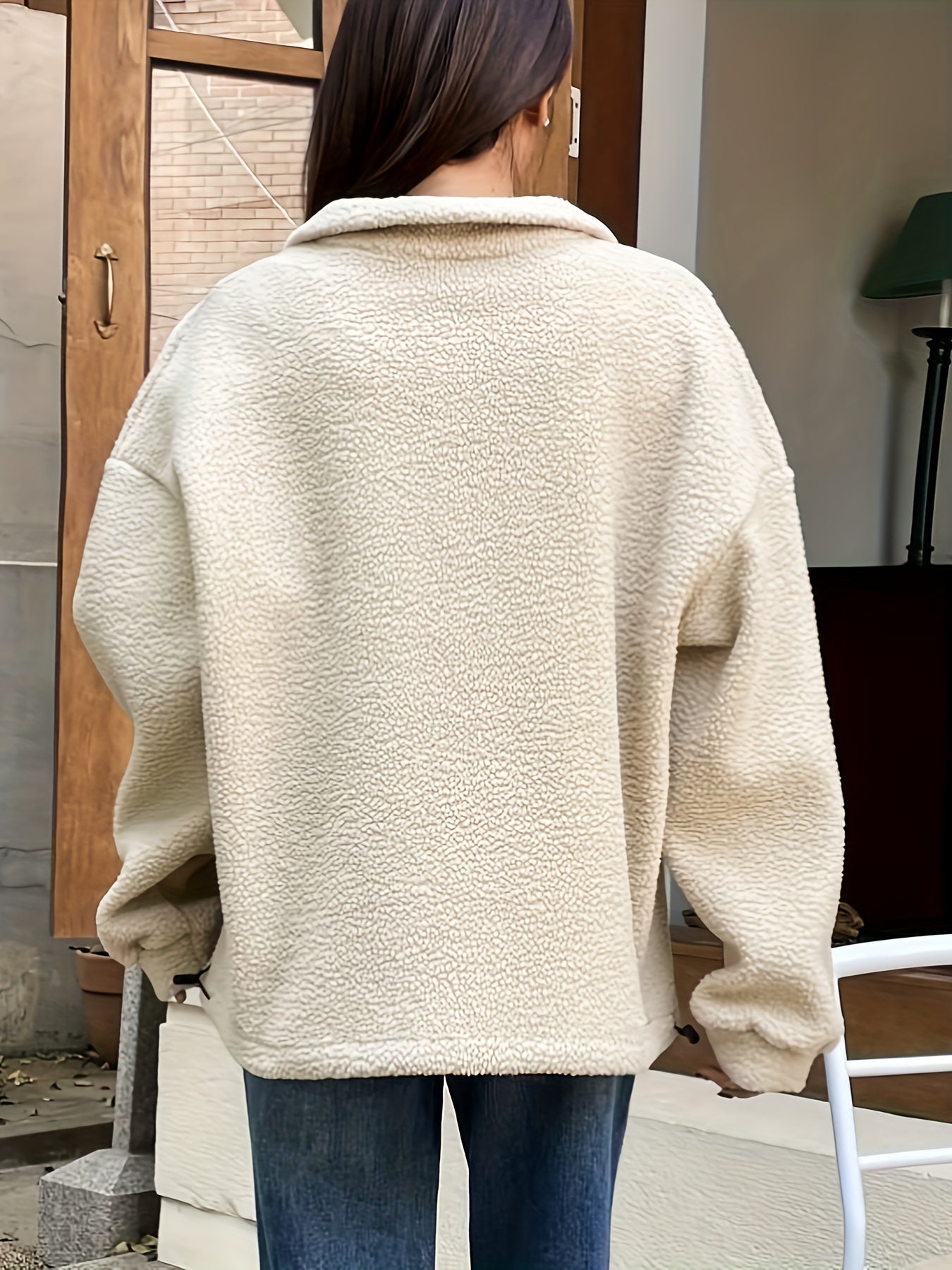 Frau in beiger Teddyjacke aus Fleece, lässig geschnitten, Herbstmode, Rückansicht.