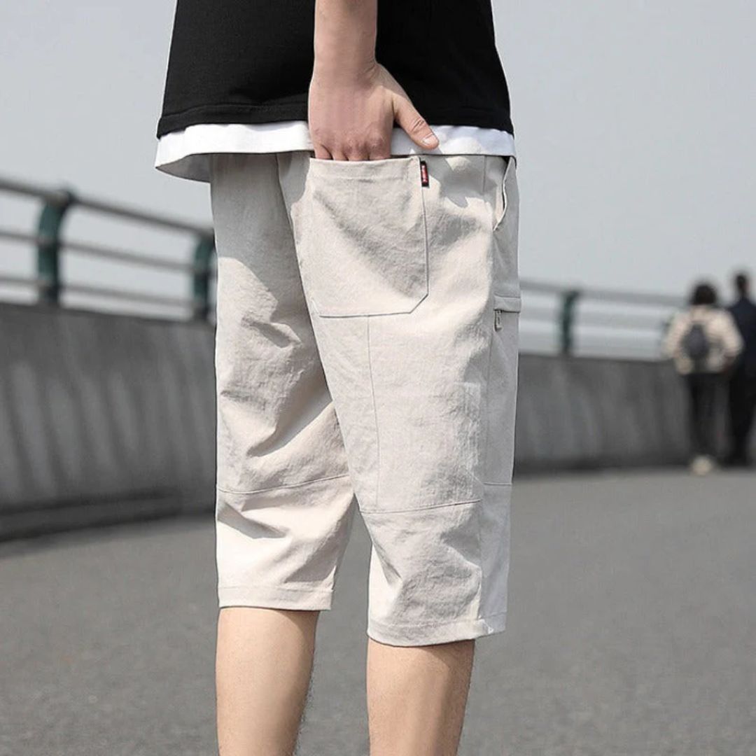 Mann in beigen Cargo-Shorts aus Baumwolle auf Brücke, lässige Sommermode.