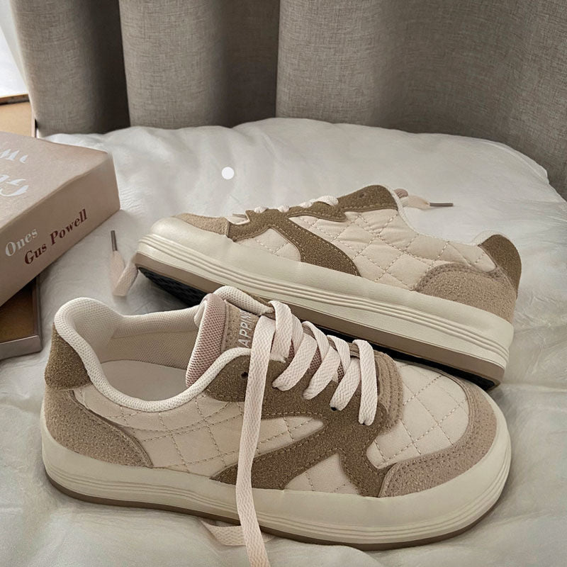 Beige Sneaker aus Wildleder und Stoff, Damen, lässig, bequem, modisch, auf Bett liegend.