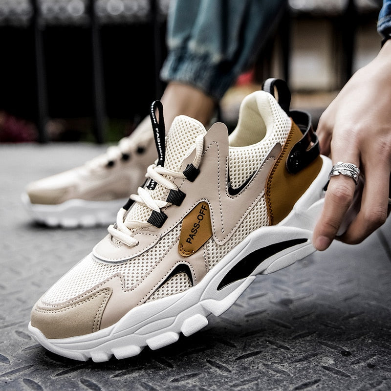 Beige Sneaker mit Mesh-Obermaterial, schwarzem Akzent, sportlich, modisch, Herren-Freizeitschuh.