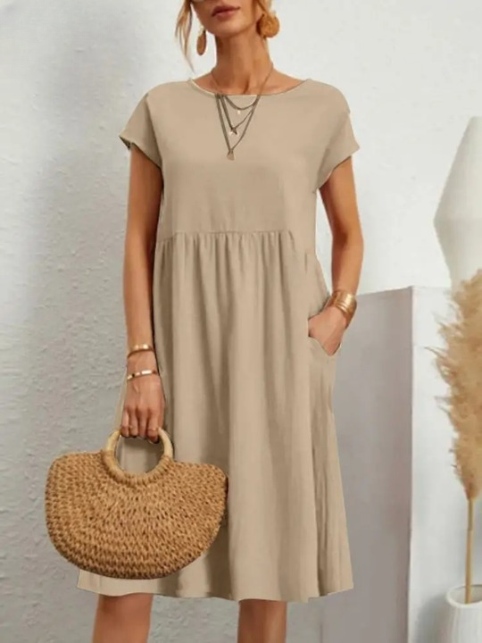Frau in beige Sommerkleid mit Strohtasche, lässiger Look, Mode für Damen, Sommeroutfit.