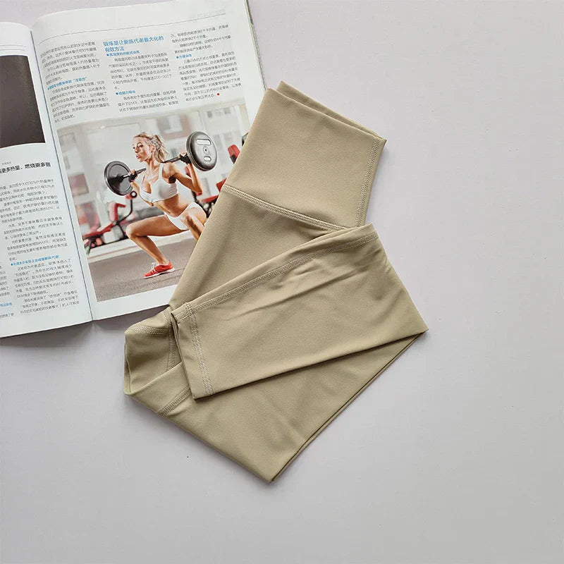 Beige Sportleggings aus Stretchmaterial auf Magazin mit Fitnessmotiv.