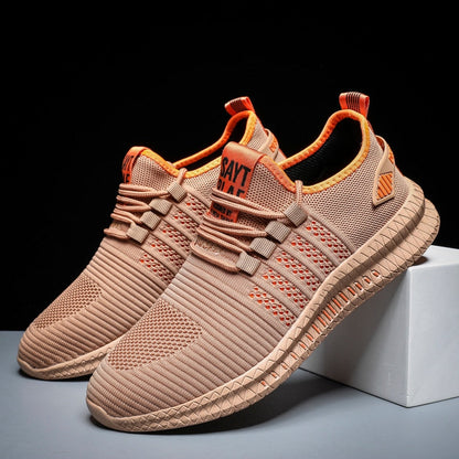 Beige Sportschuhe aus Mesh mit orangen Akzenten, rutschfeste Sohle, ideal für Laufen und Fitness.