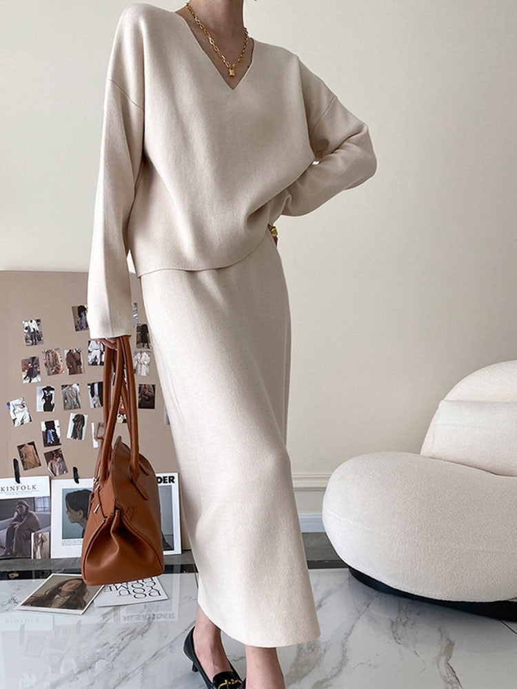 Damenbeige Strickkleid mit V-Ausschnitt, elegantes Design, Herbstmode, braune Handtasche.