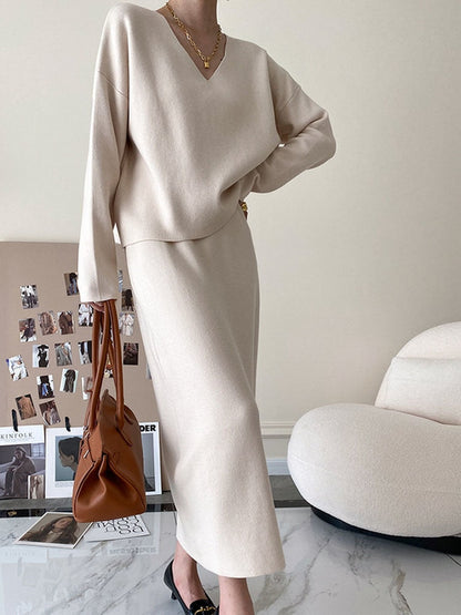 Damenbeige Strickkleid mit V-Ausschnitt, elegantes Design, Herbstmode, braune Handtasche.