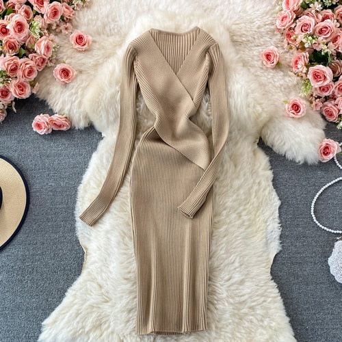 Beiges Strickkleid Damen, langärmelig, V-Ausschnitt, elegant, auf Teppich mit Rosen.