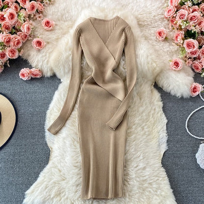 Beiges Strickkleid Damen, langärmelig, V-Ausschnitt, elegant, auf Teppich mit Rosen.