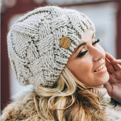 Frau mit beiger Strickmütze, Wintermode, warm, stilvoll, Accessoire, Outdoor, gemütlich.