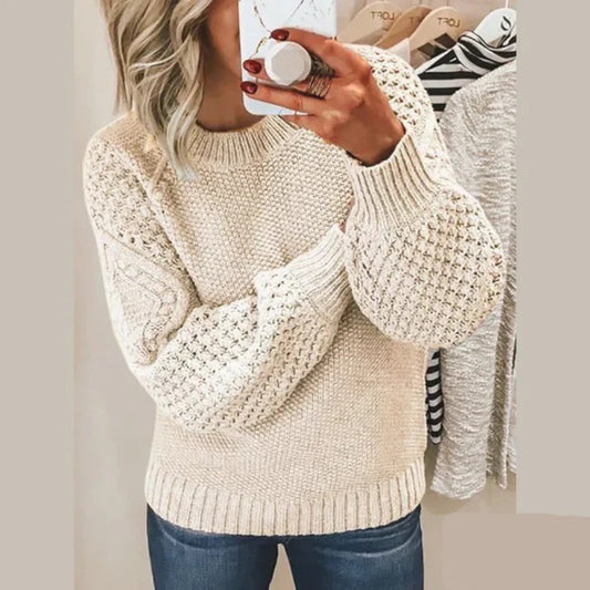 Frau in beigem Strickpullover mit Zopfmuster, lässig, modisch, Herbstmode, Damenbekleidung.