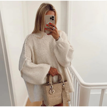 Frau mit beigem Strickpullover und beiger Designer-Handtasche, Selfie im Spiegel.