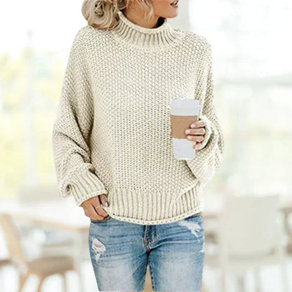 Frau in cremefarbenem Strickpullover mit Kaffeebecher, lässige Herbstmode, gemütlich.