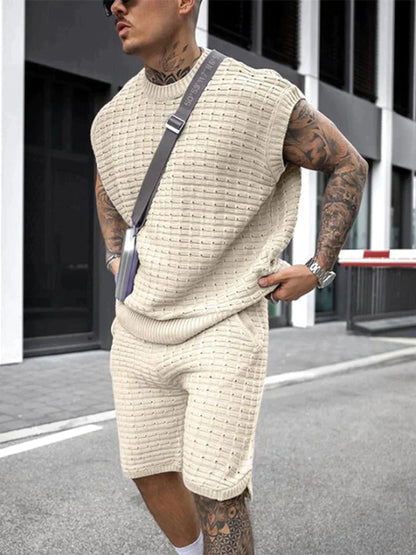 Mann in cremefarbenem Strick-Set, ärmelloses Oberteil und Shorts, urbaner Stil, Sommermode.