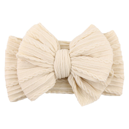 Beige Baby-Stirnband aus Baumwolle mit großer Schleife, geripptes Design, modisches Accessoire.