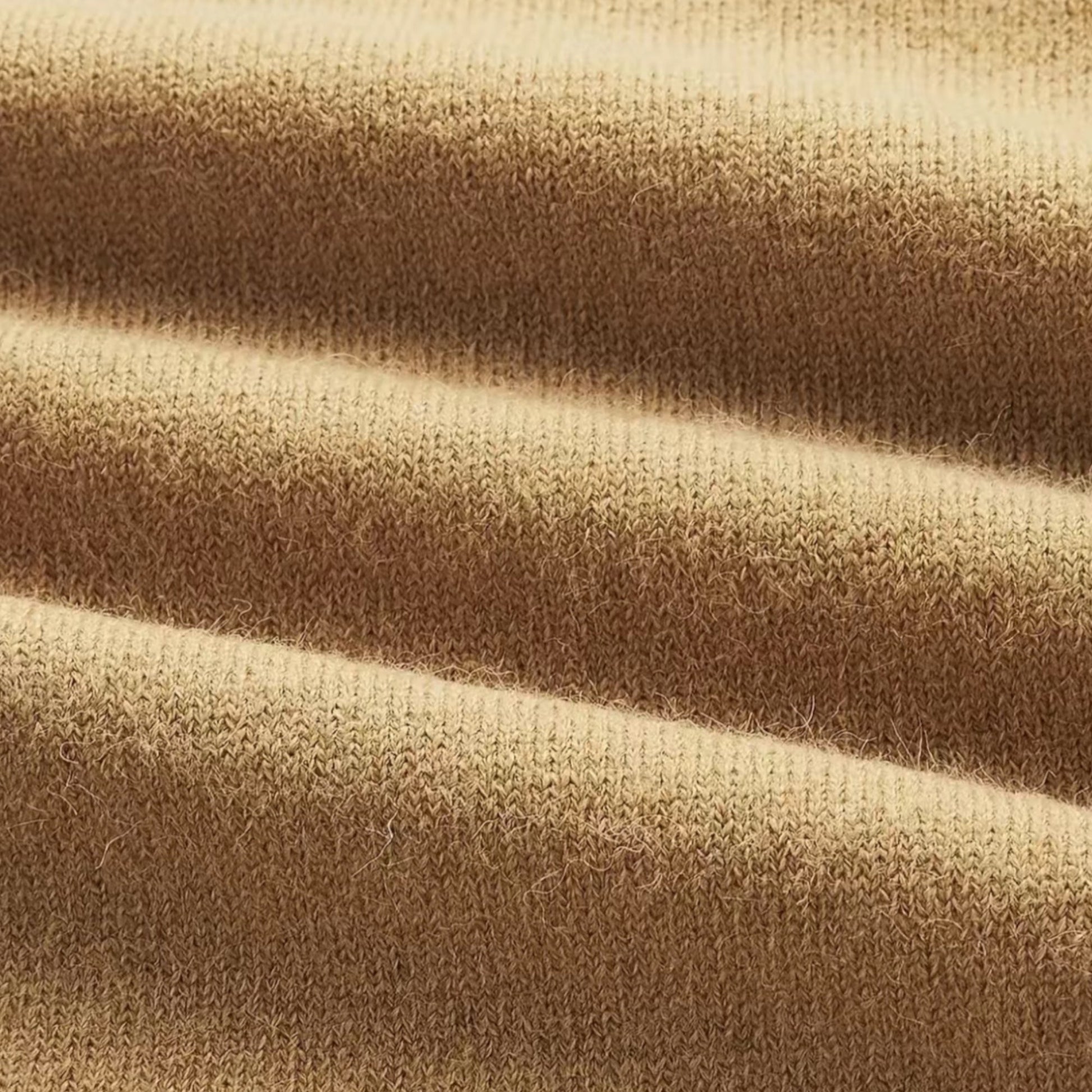 Beigefarbener Kaschmirstoff, weiche Textur, hochwertige Strickware, luxuriöses Material.