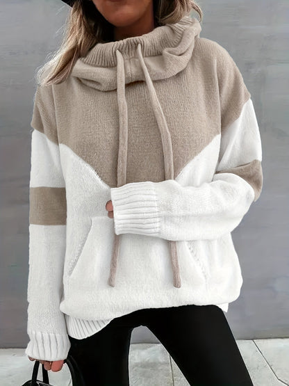 Frau in beige-weißem Strickpullover mit Kapuze, Kordeln und Taschen, modisch, gemütlich.