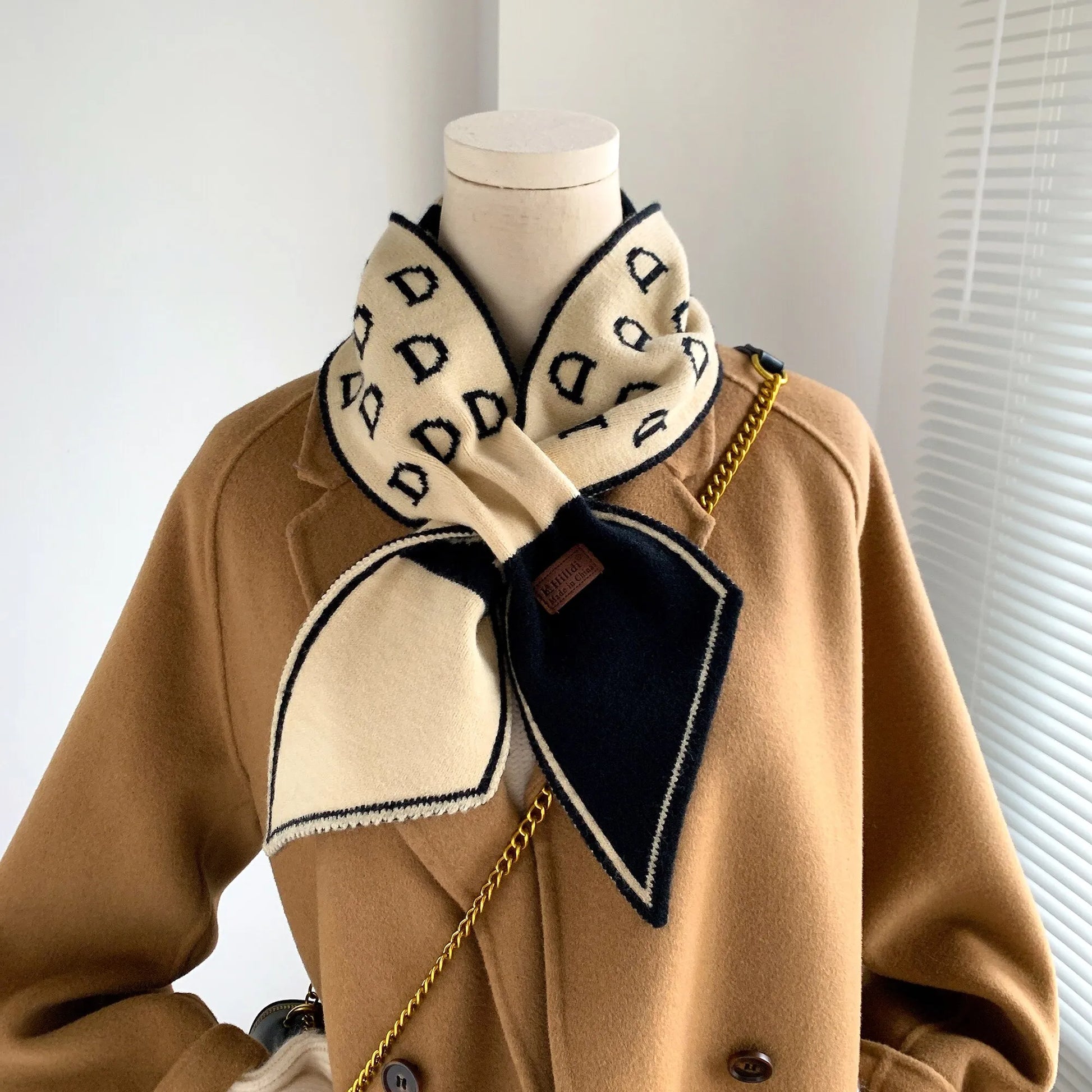 Beige Mantel mit schwarz-weißem Schal, geometrisches Muster, Damenmode, Winteraccessoire.