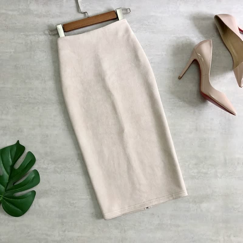 Beiger Bleistiftrock aus Baumwolle auf Kleiderbügel, daneben beigen High Heels, Modeaccessoires.