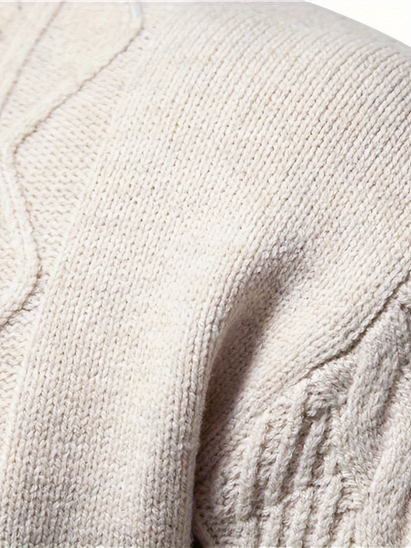 Beiger Strickpullover aus Baumwolle, Nahaufnahme, weiches Material, modisches Design.