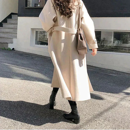 Frau im beigen Wollmantel mit Tasche, Herbstmode, stilvolle Straßenkleidung, schwarze Stiefel.