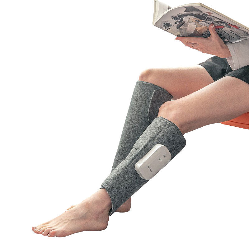 Person mit grauen Beinmassagemanschetten, liest ein Buch, Entspannung, Massagegerät, Wellness.