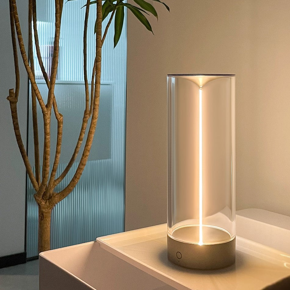 Moderne LED-Tischlampe aus Glas, zylindrisch, warmweißes Licht, minimalistisches Design.