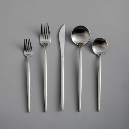 Fünfteilige Edelstahl-Besteckset, bestehend aus Gabeln, Messer, Löffeln auf grauem Hintergrund.