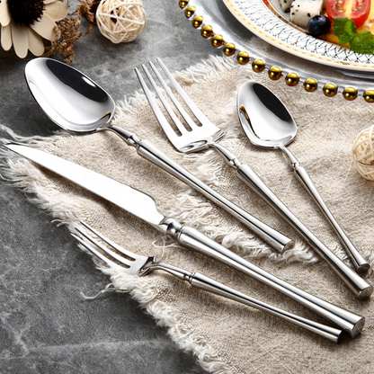 Elegantes Edelstahl-Besteckset auf Leinentuch, bestehend aus Messer, Gabel, Löffel.