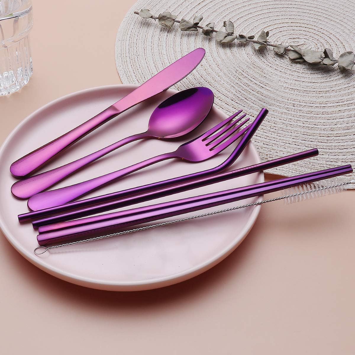 Lila Edelstahl-Besteckset auf Teller, inkl. Strohhalme und Reinigungsbürste, modern und stilvoll.