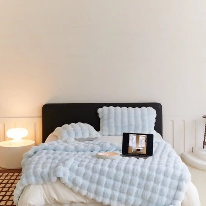 Gemütliches Schlafzimmer mit blauem Bettüberwurf, Tablet auf Bett, moderne Nachttischlampe.
