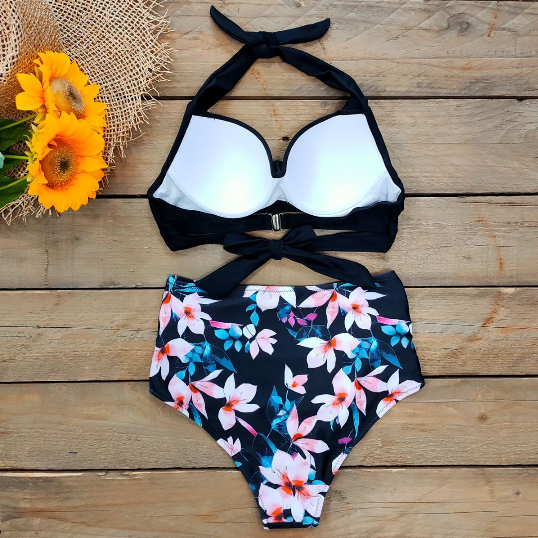 Schwarz-weißer Bikini mit Blumenmuster, hoher Taille, auf Holzhintergrund, Sonnenblumen-Deko.