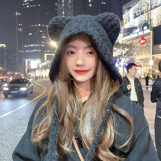 Frau mit schwarzer Bärenmütze aus Plüsch, Nacht, Stadtstraße, Modeaccessoire, Winterkleidung.