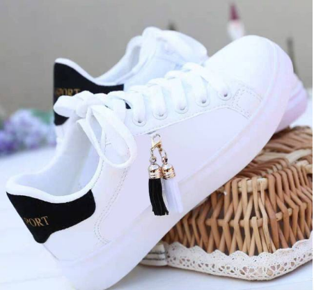 Weiße Sneaker mit schwarzem Detail und Quasten, modische Freizeitschuhe für Damen.