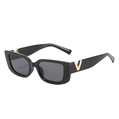 Schwarze Sonnenbrille mit rechteckigem Rahmen und goldenen Details, modisch, UV-Schutz.