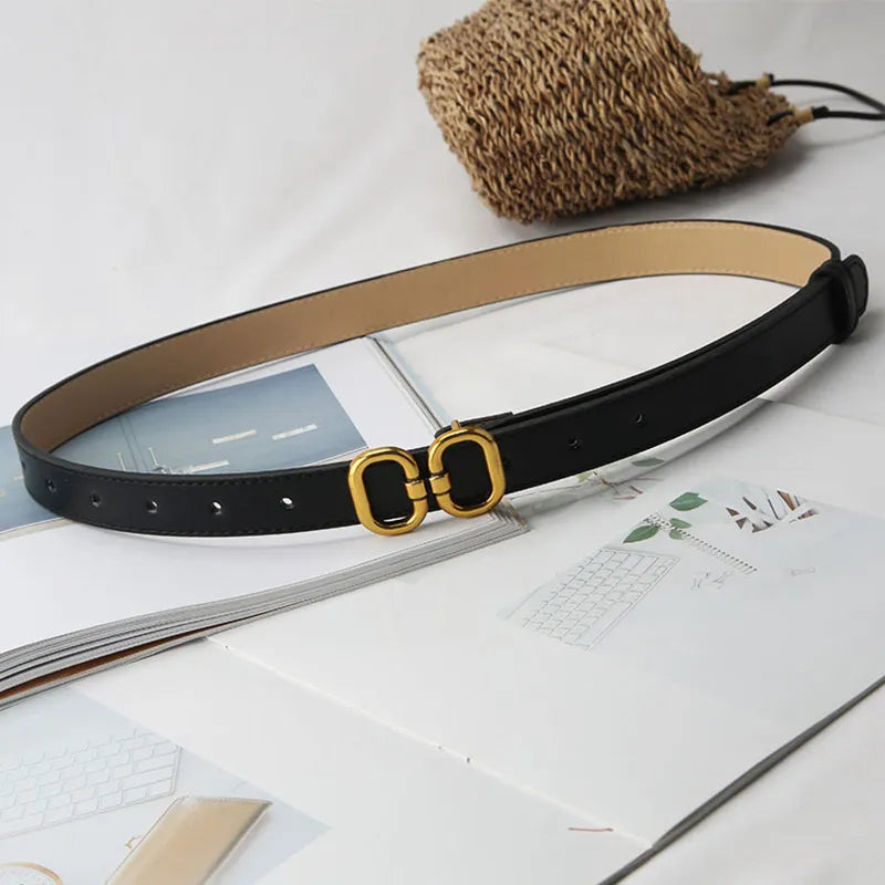 Schwarzer Ledergürtel mit goldener Schnalle auf offenem Buch, modisches Accessoire.
