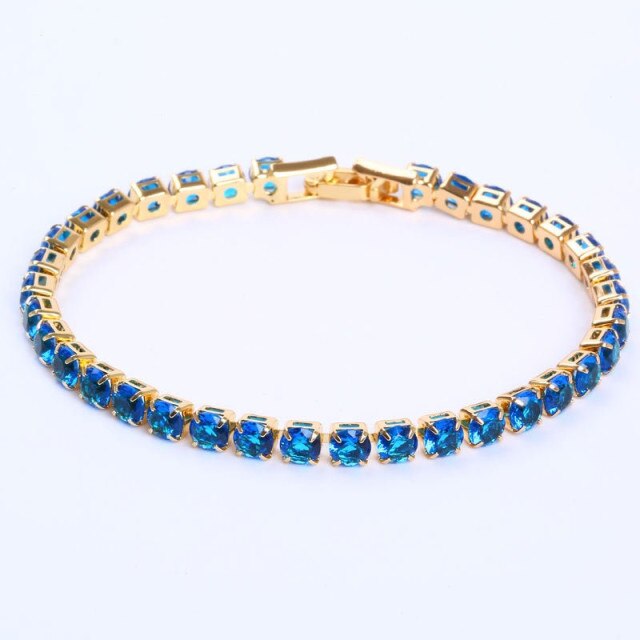 Goldenes Armband mit blauen Edelsteinen, elegantes Schmuckstück, luxuriöses Design.