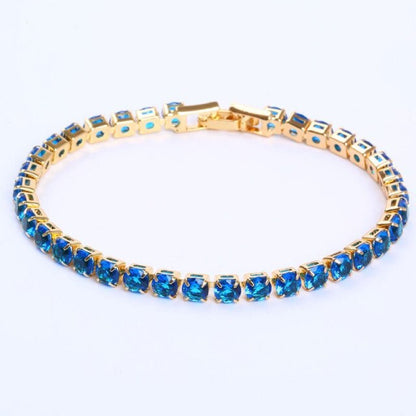 Goldenes Armband mit blauen Edelsteinen, elegantes Schmuckstück, luxuriöses Design.